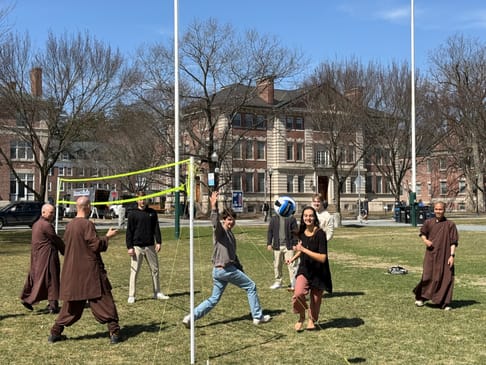 Monastics and students playing volleyball on the Dartmouth Green