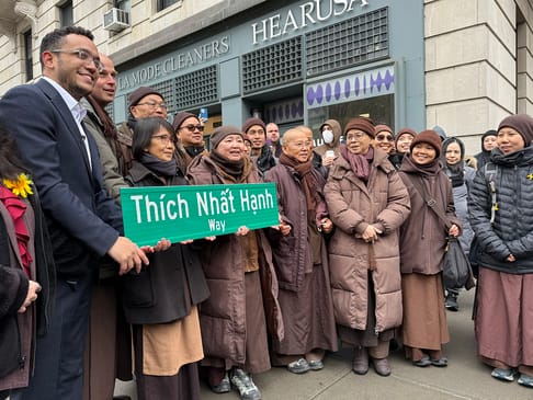Monastics holding the new "Thich Nhat Hanh Way" sign with NYC Mayor Shaun Abreu, April 11, 2025