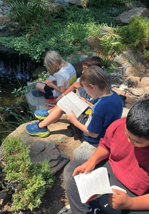 Kids reading outdoors