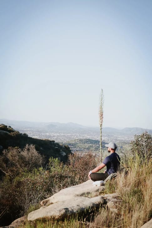 Man meditating on mountain